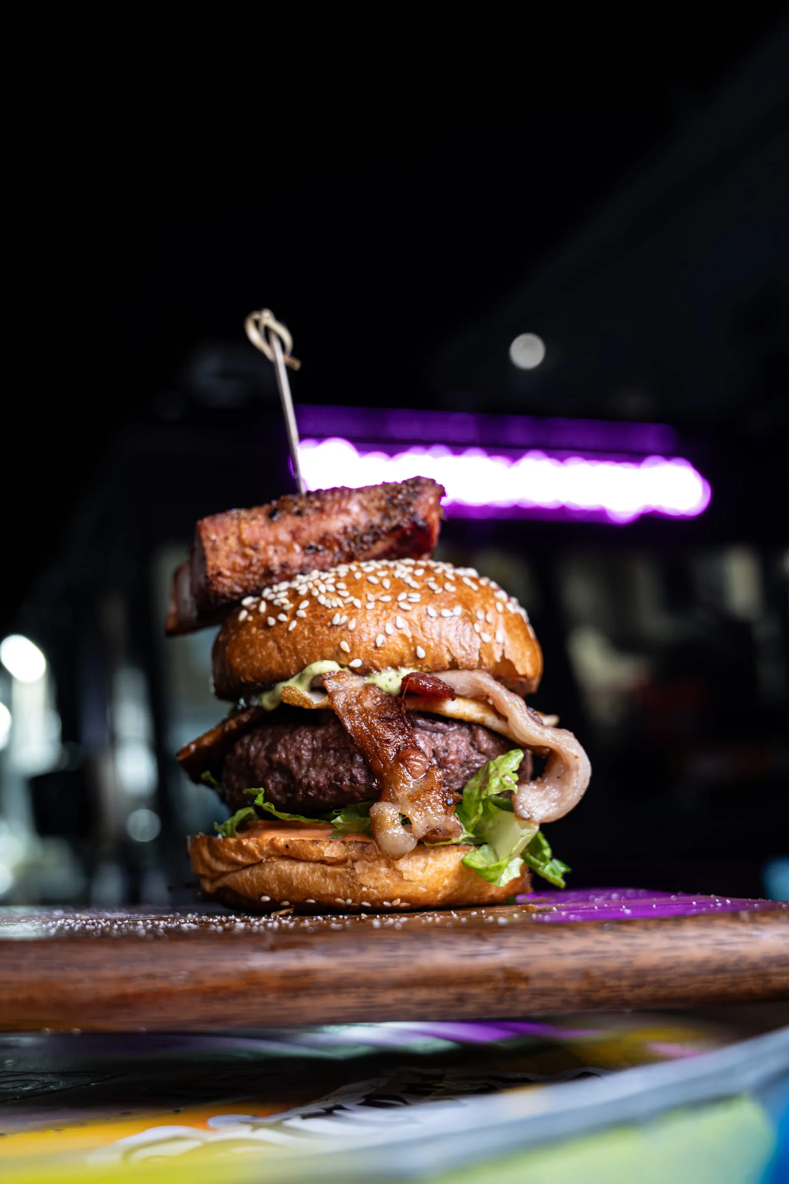 Stacked burger under neon — Food photography by JP Media Groups