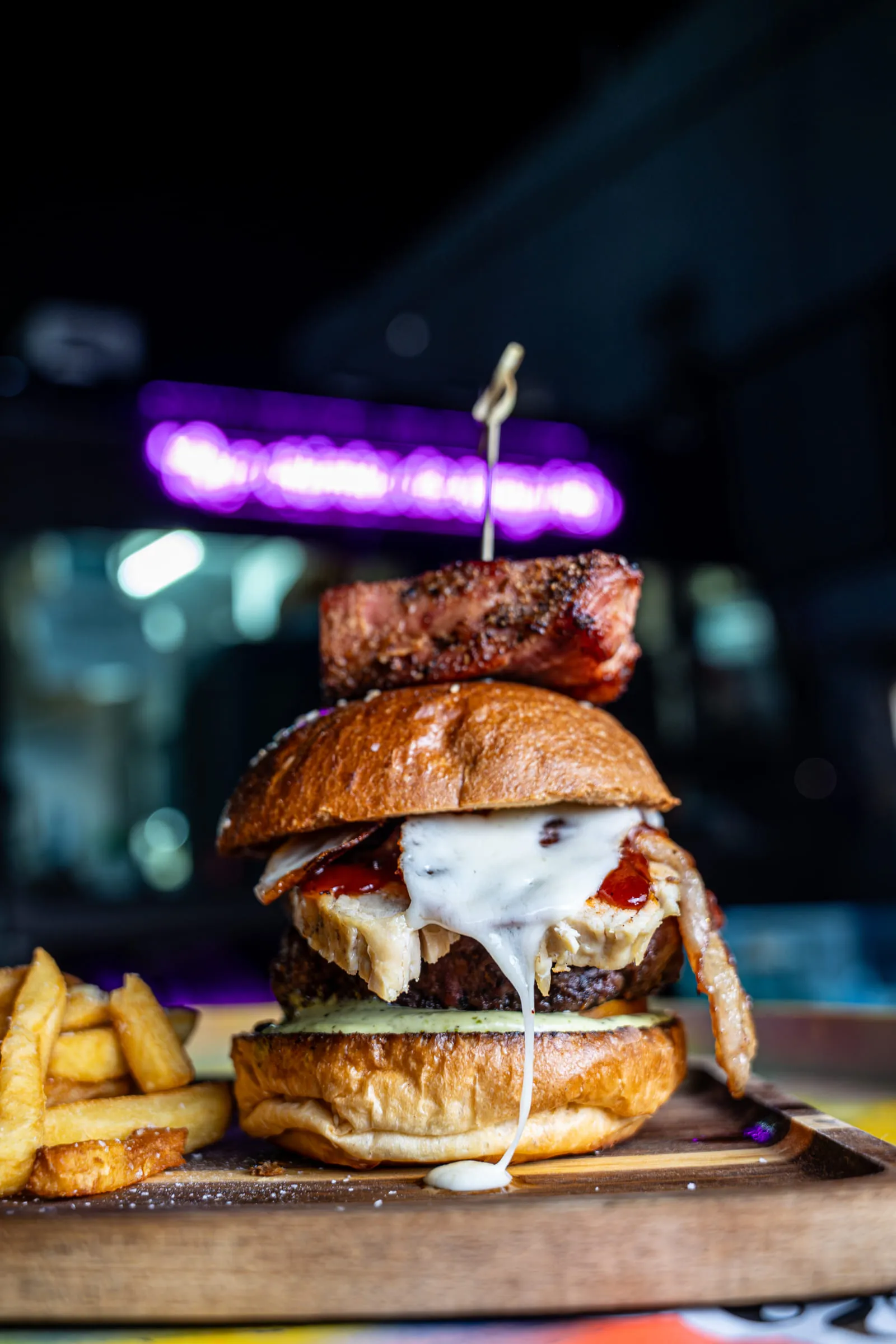 Cheese pull burger under neon — Food photography by JP Media Groups