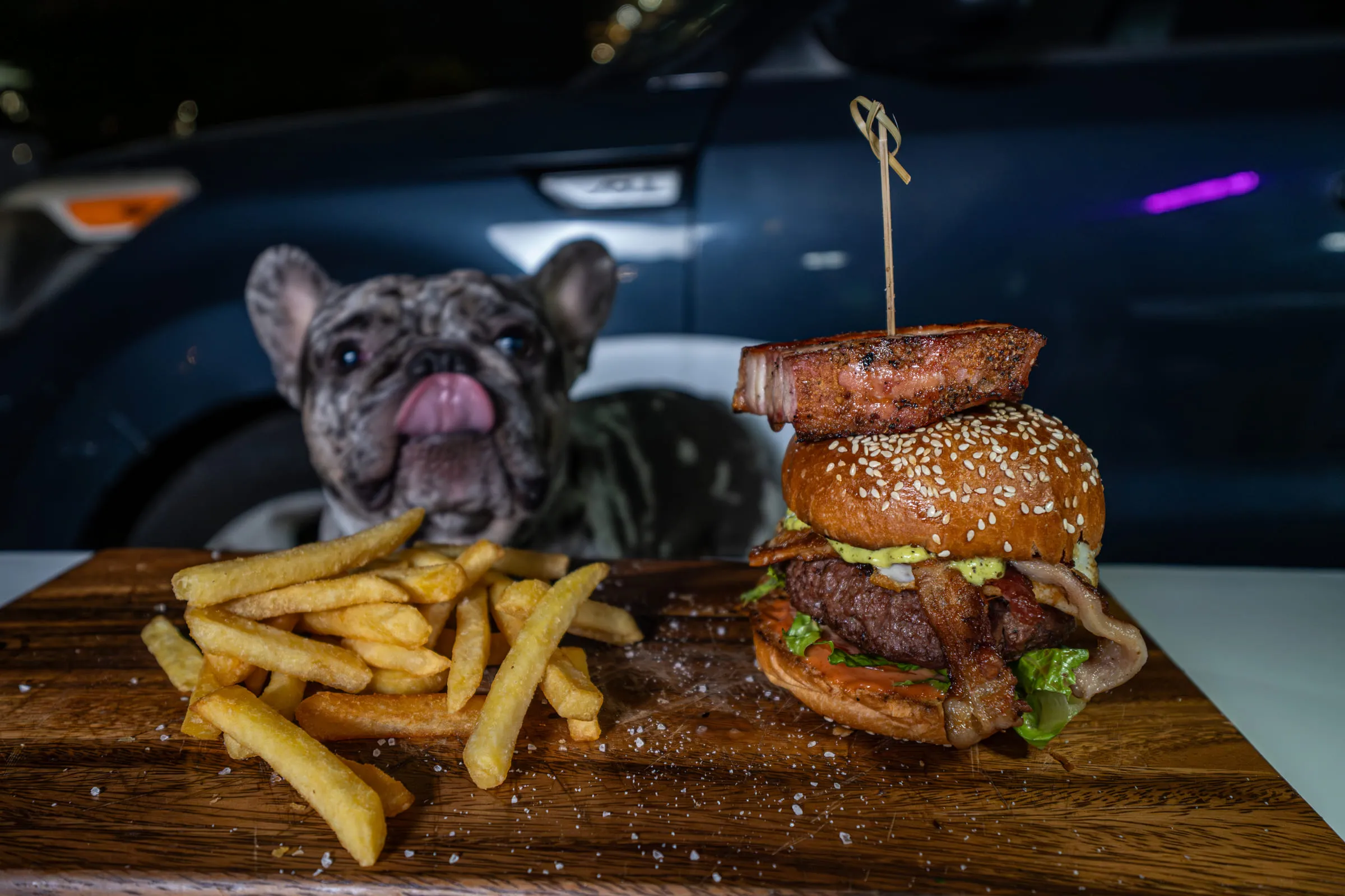 Burger and fries on wood board — Food photography by JP Media Groups