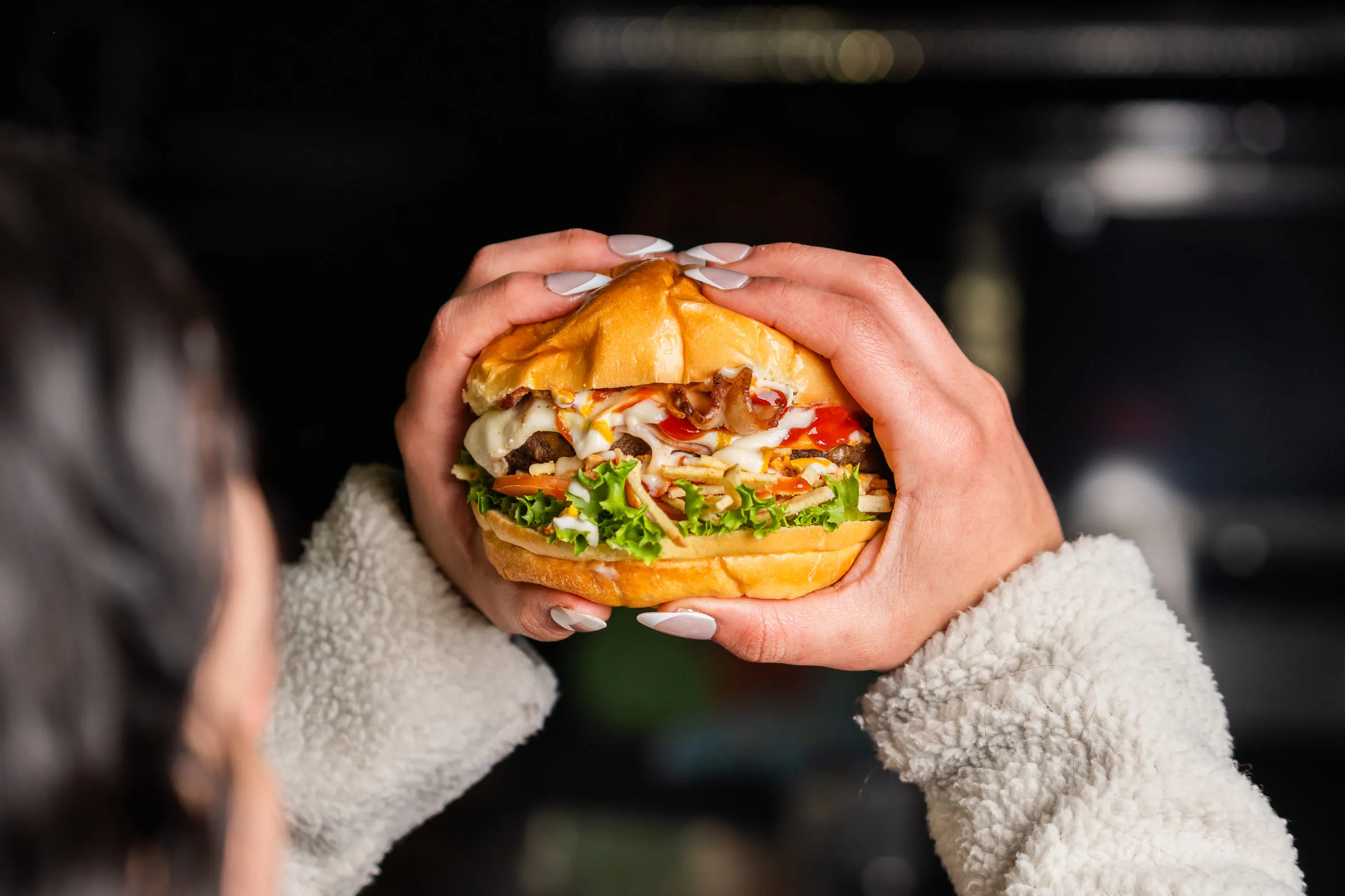 Burger held in hands — Food photography by JP Media Groups