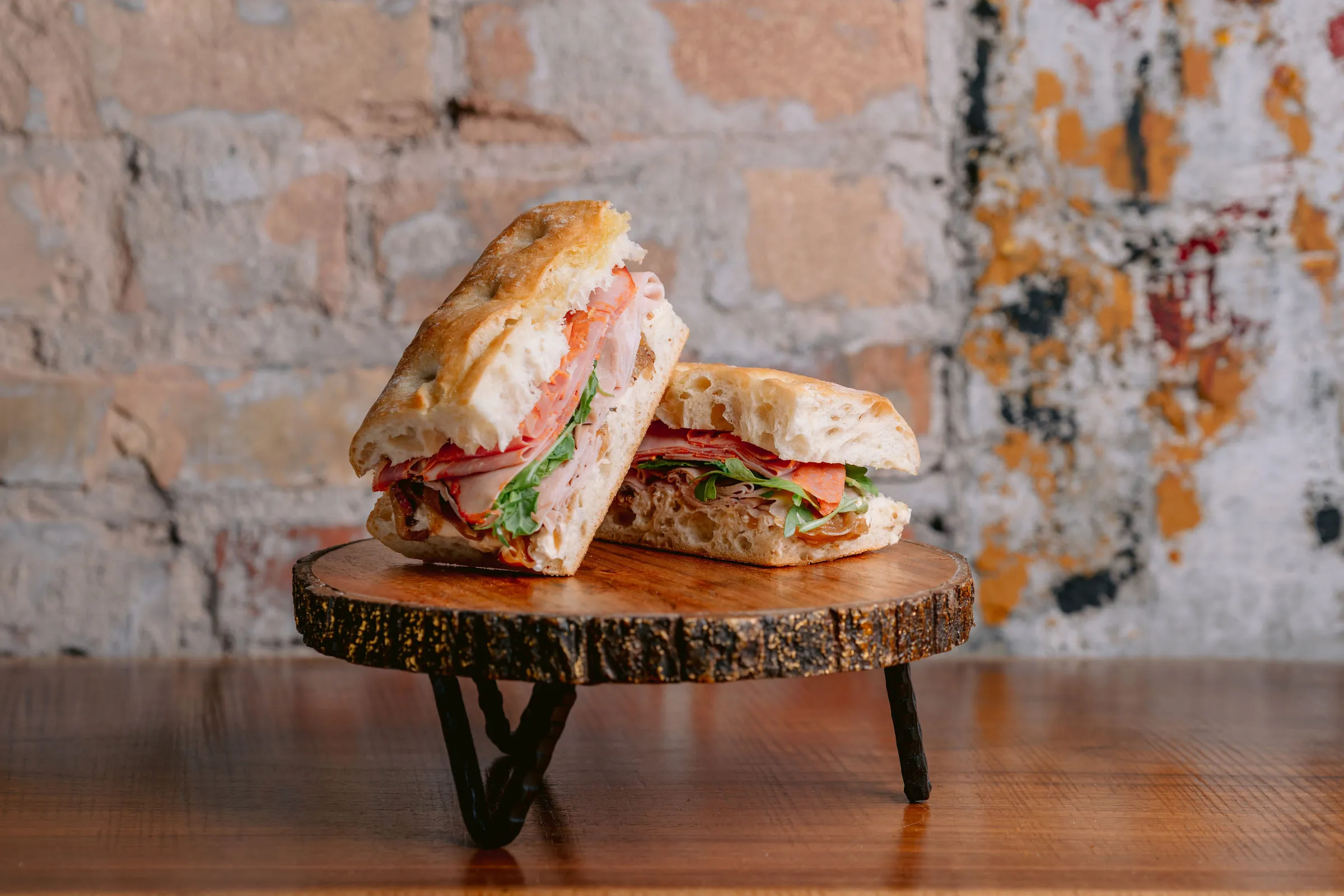 Sandwich halves on wood slice — Food photography by JP Media Groups